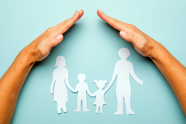 Paper family in hand isolated on blue background Paper family in hand isolated on blue background